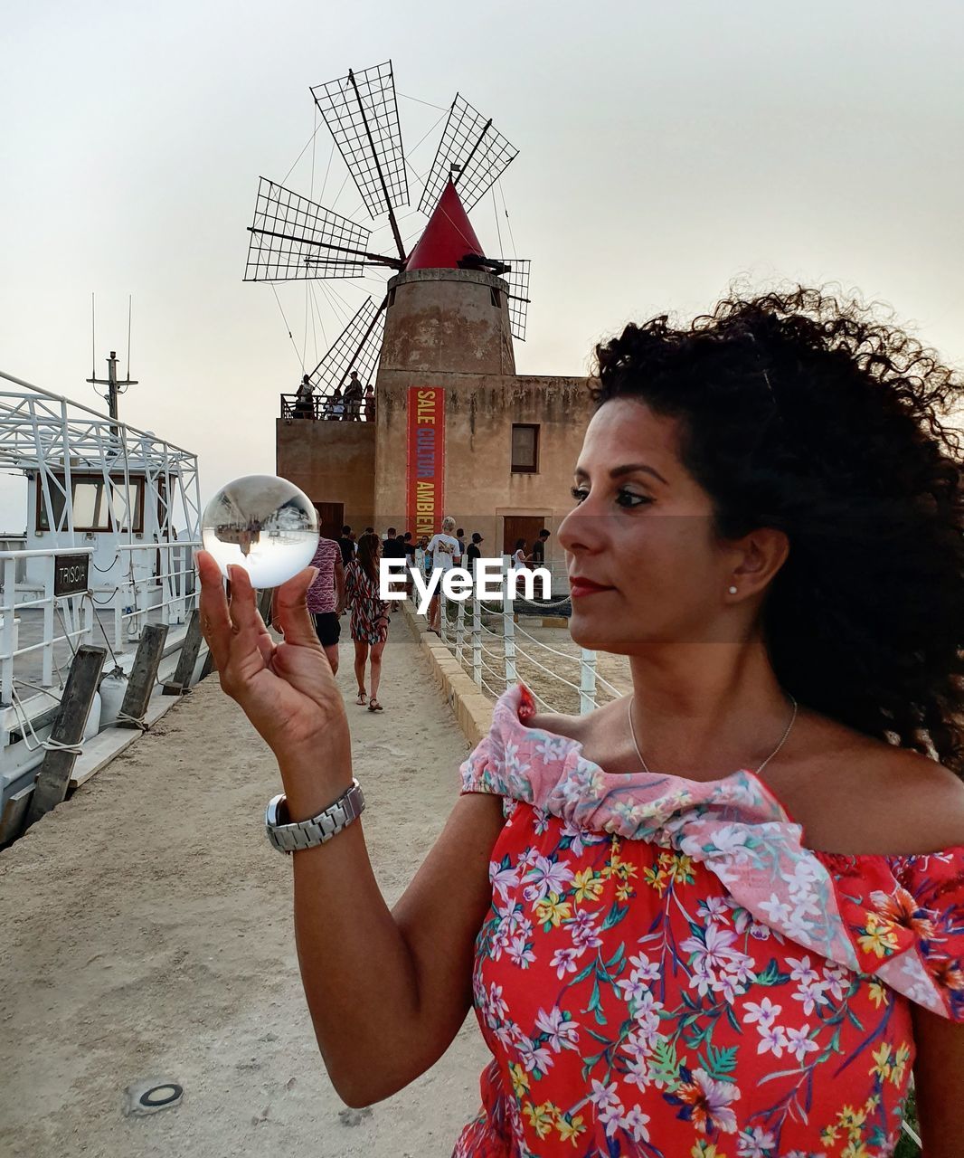 PORTRAIT OF WOMAN LOOKING AWAY AGAINST BUILT STRUCTURE