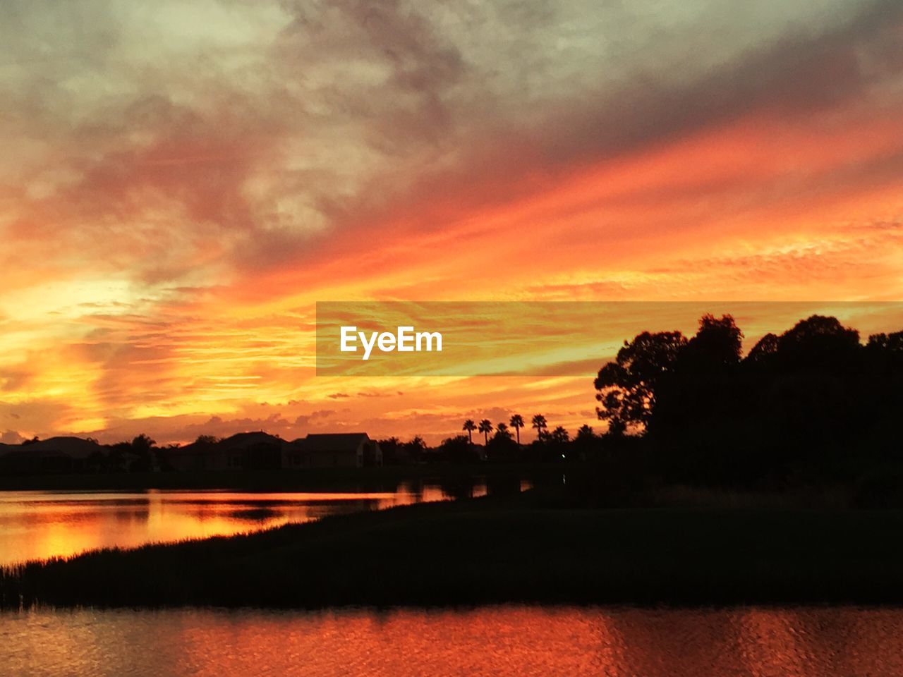 Scenic view of lake against orange sky