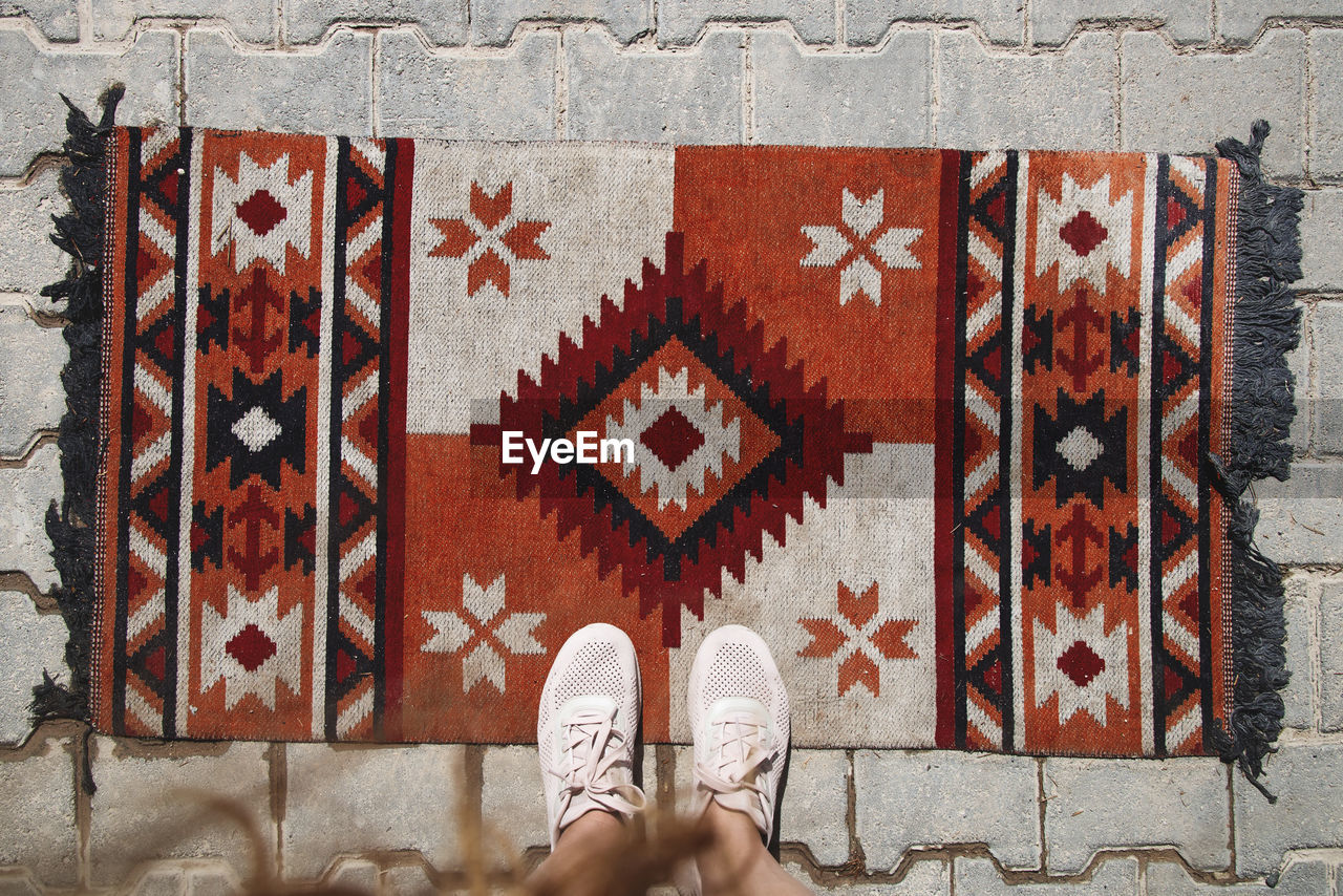 Woman tourist stands on a traditional turkish carpet