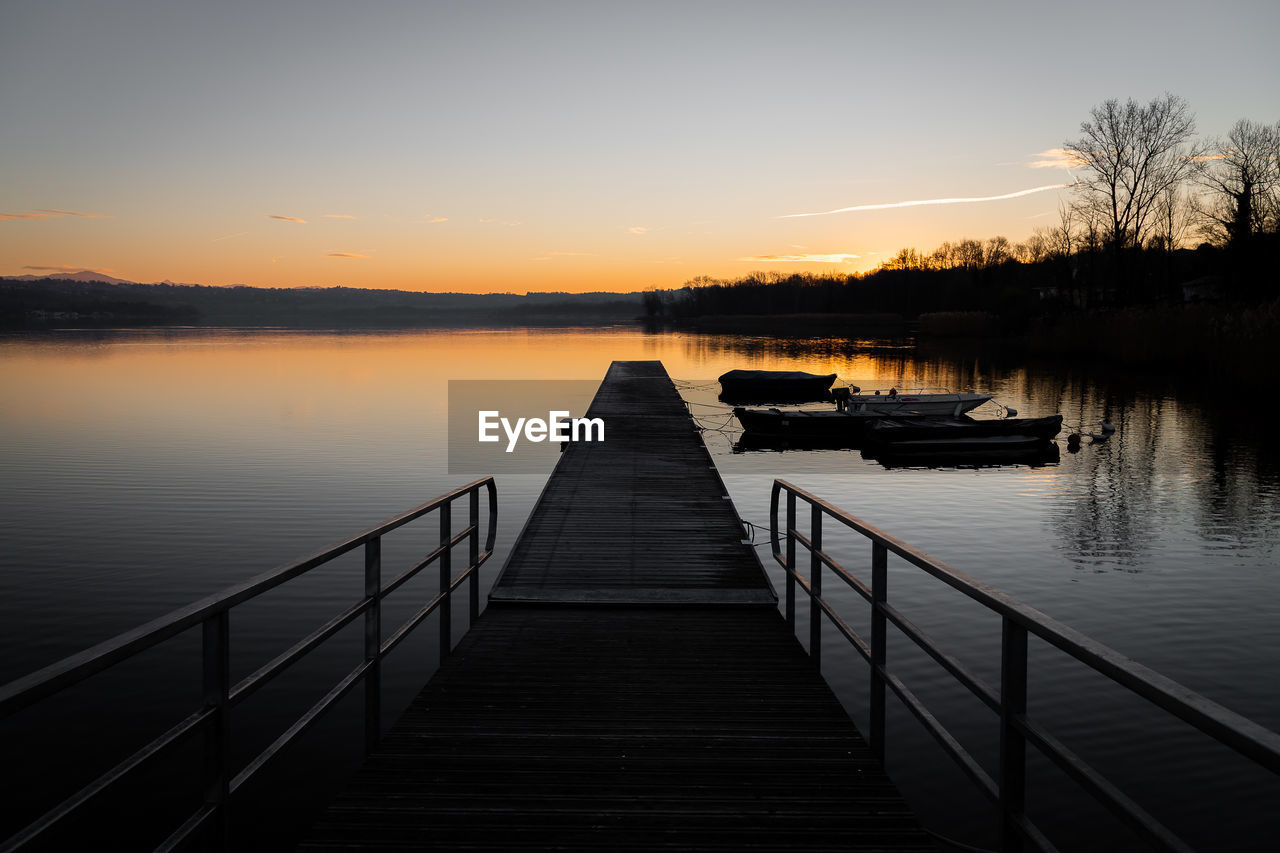 Pier over lake against sky during sunset, varese lake, italy 