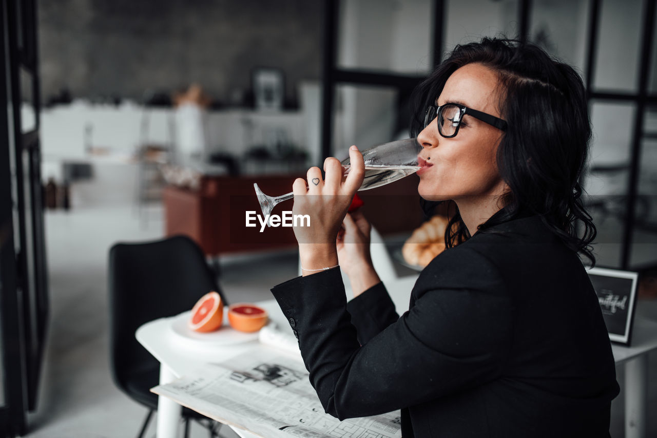 Woman drinking glass at home