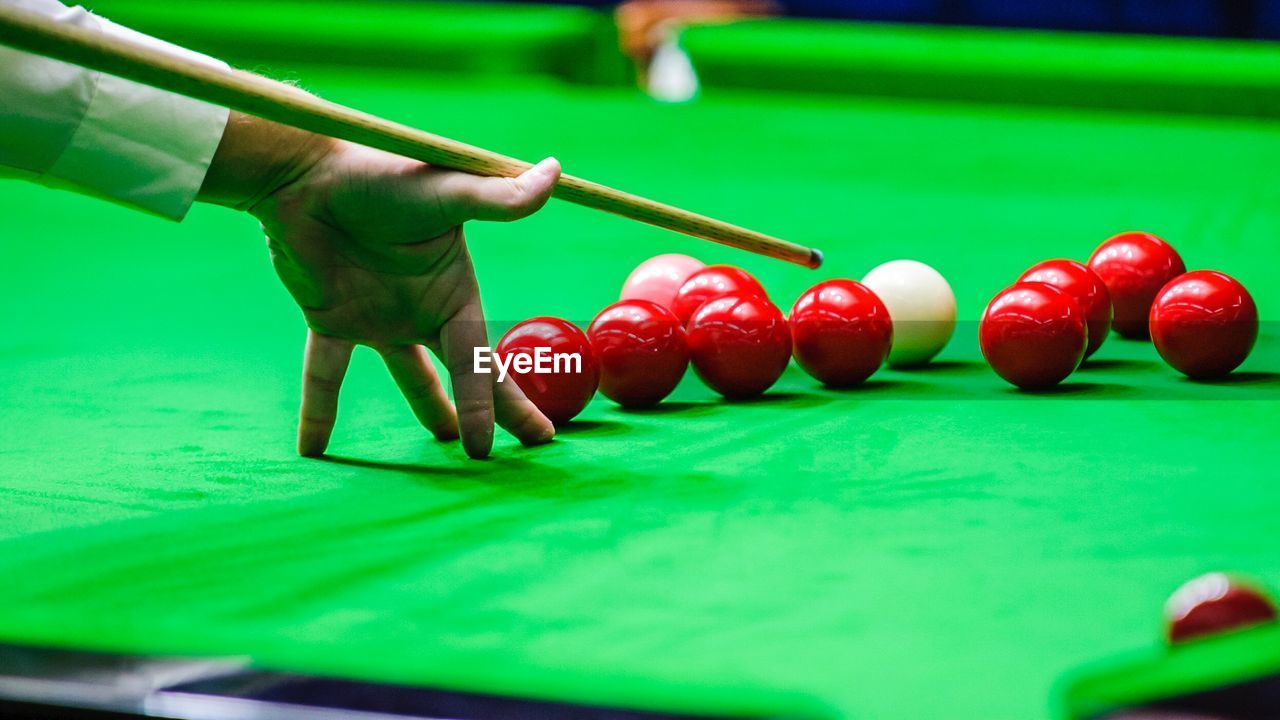 Close-up of hand playing pool on table