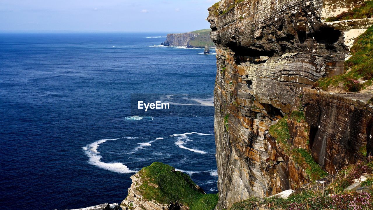 Cliffs of moher by sea against sky