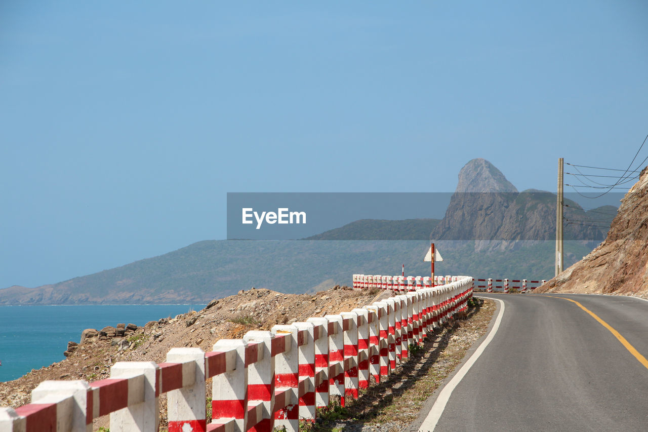 PANORAMIC VIEW OF ROAD BY SEA AGAINST CLEAR BLUE SKY