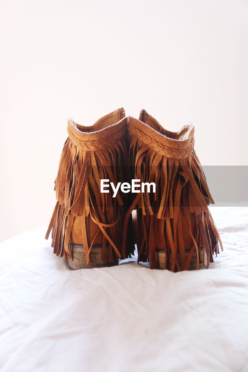 Close-up of leather cowboy boots on bed 