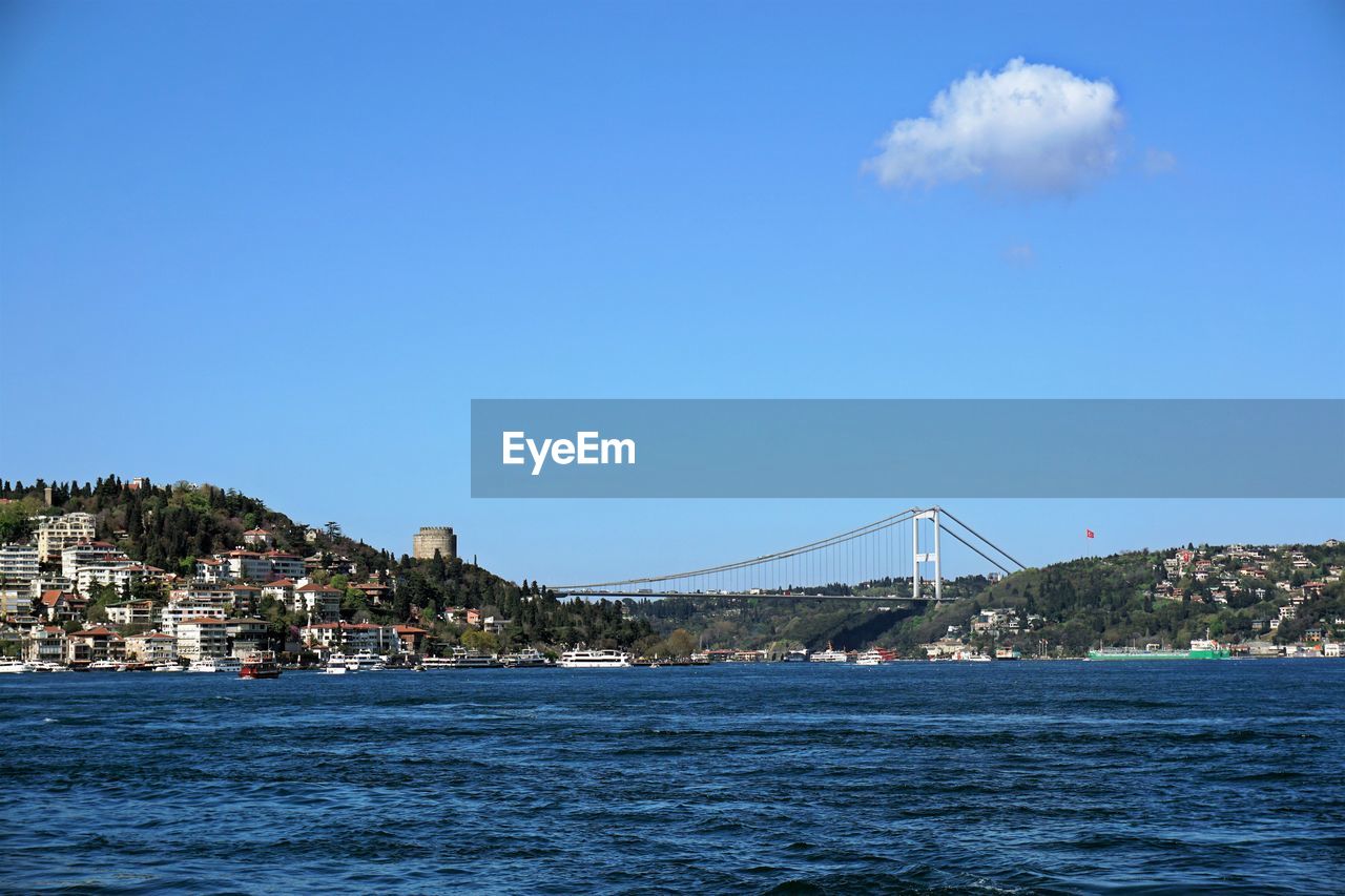 Bridge over sea and buildings against sky