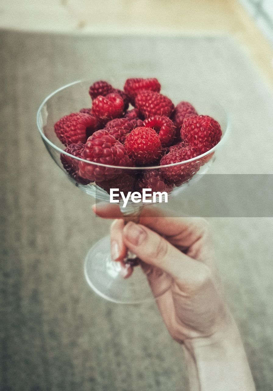 MIDSECTION OF WOMAN HOLDING STRAWBERRY