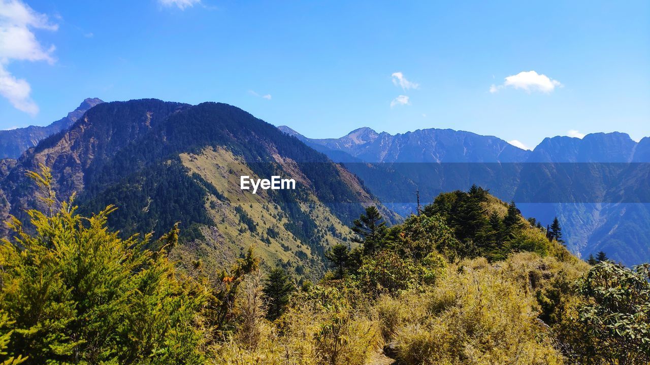 Scenic view of mountains against blue sky