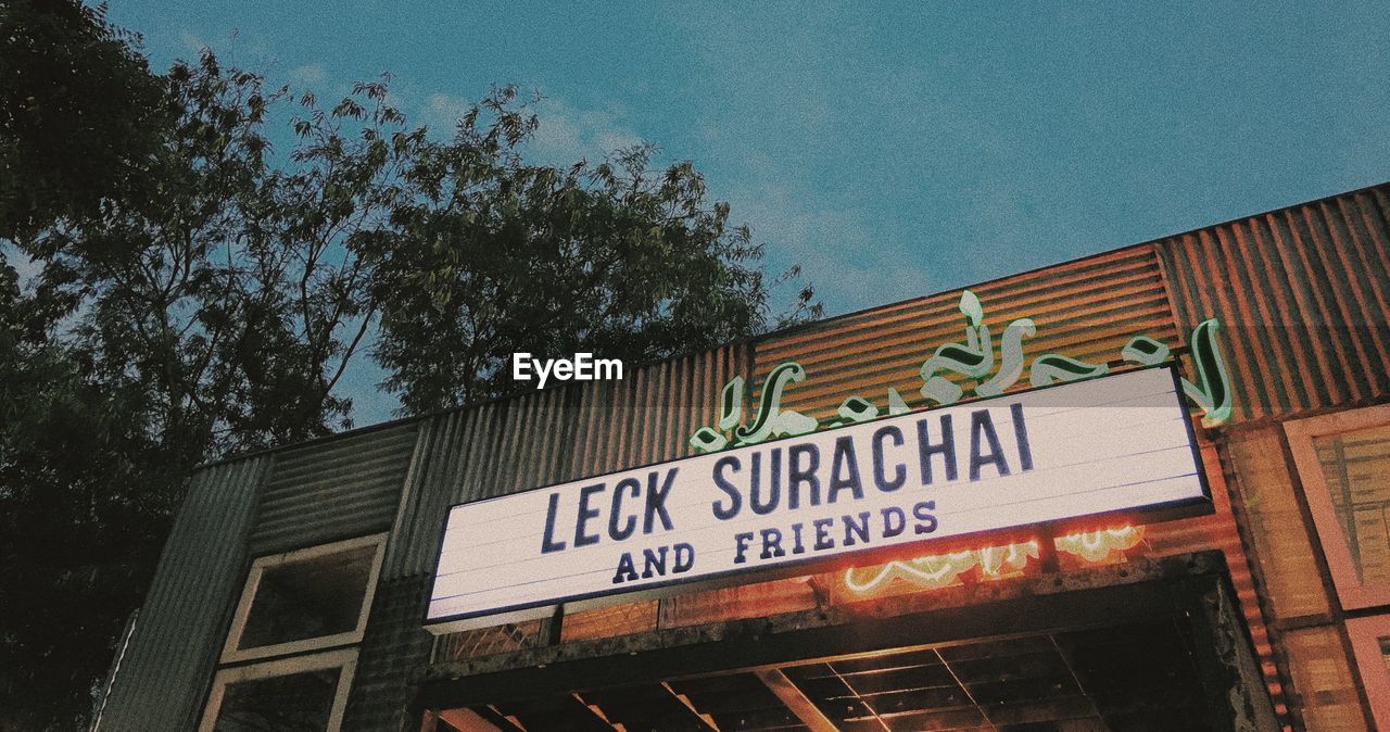 LOW ANGLE VIEW OF INFORMATION SIGN ON BUILDING AGAINST SKY