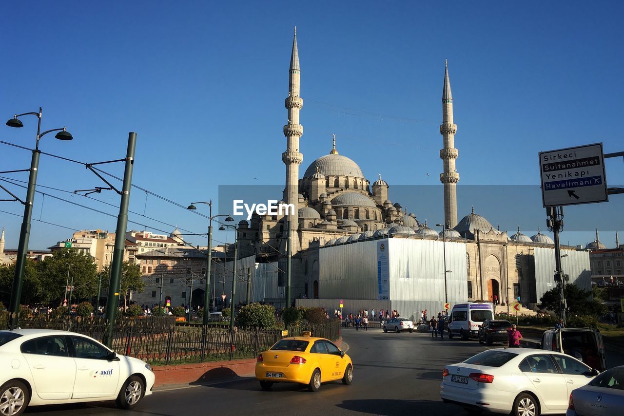 Vehicles on street by sultan ahmed mosque against sky