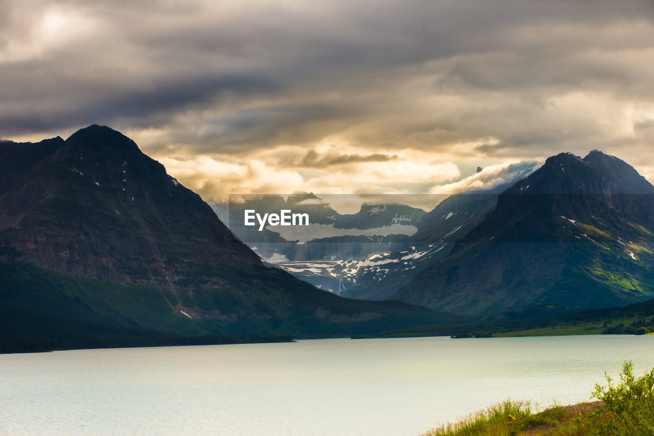 SCENIC VIEW OF LAKE AMIDST MOUNTAINS AGAINST SKY