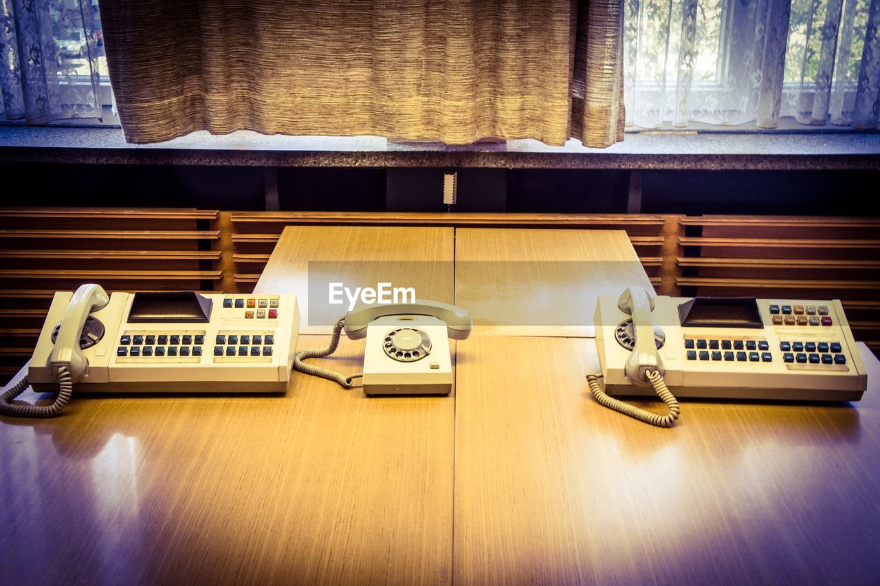 High angle view of landline phones on wooden table