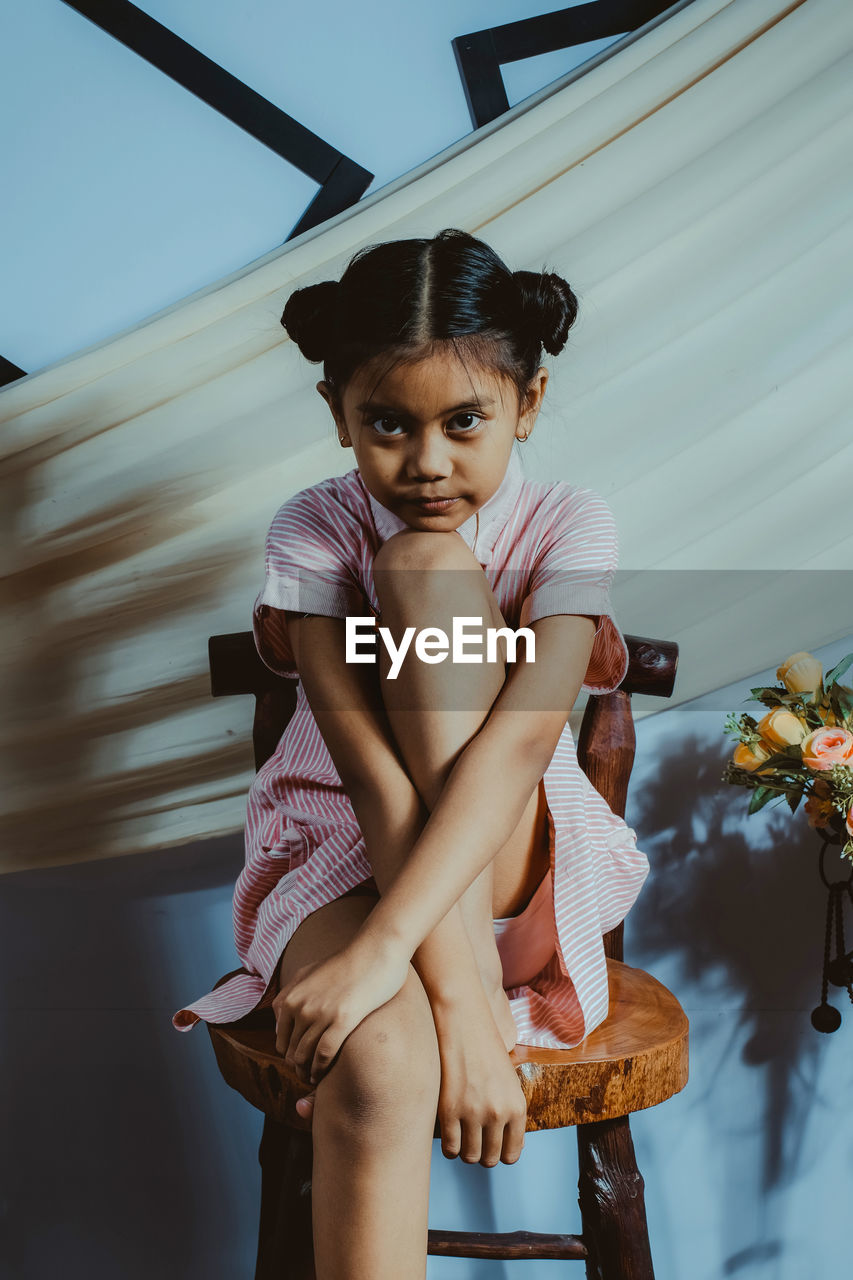 Portrait of girl sitting on chair