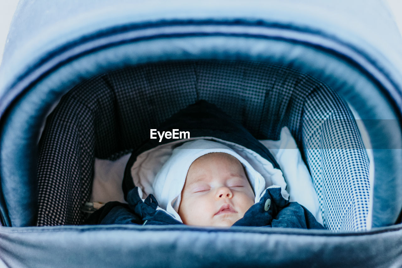 Close-up of baby sleeping in baby carriage