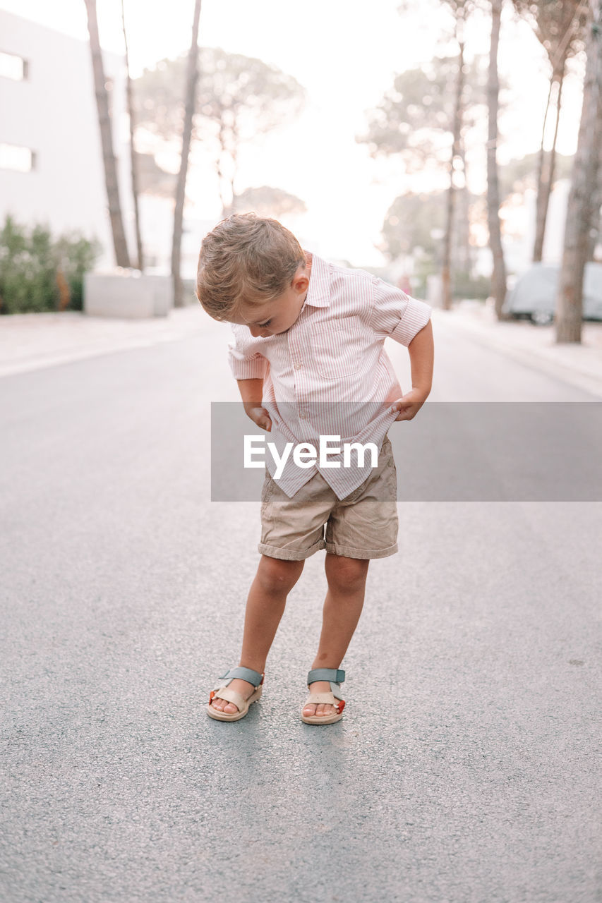 childhood, child, one person, full length, men, spring, toddler, casual clothing, day, looking, lifestyles, city, leisure activity, standing, outdoors, baby, street, nature, looking down, footwear, emotion, white, person, architecture, blond hair, fun, motion, road, copy space