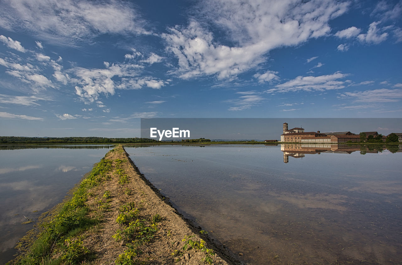 water, reflection, sky, horizon, morning, shore, sea, cloud, nature, coast, landscape, architecture, environment, sunlight, travel, built structure, travel destinations, dusk, reservoir, scenics - nature, building, no people, land, beauty in nature, rural area, blue, outdoors, city, body of water, tranquility, tourism, building exterior, plant, beach, waterway, ocean, rural scene, wetland, transportation, history, hill, religion, business finance and industry, bay, day