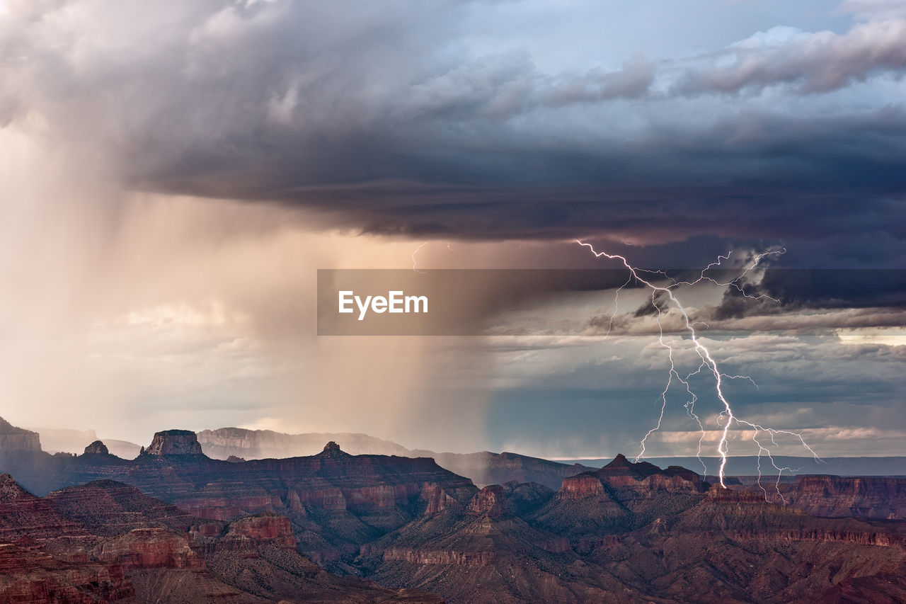 View of rock formations on landscape against cloudy sky