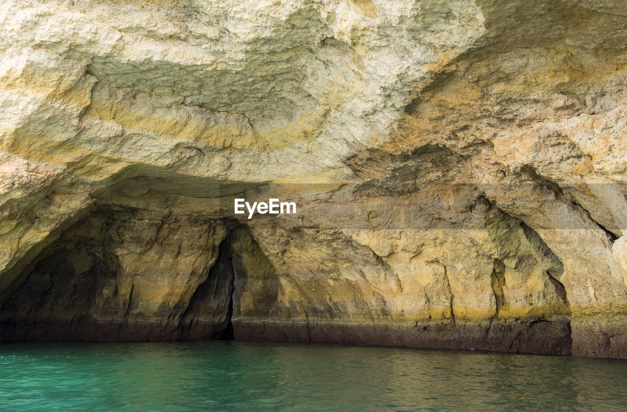 cave, water, rock, rock formation, sea cave, beauty in nature, geology, formation, no people, nature, wadi, physical geography, tranquility, scenics - nature, day, waterfront, non-urban scene, outdoors, cliff, eroded, tranquil scene, land, sea, idyllic, mountain, terrain, travel destinations, rough