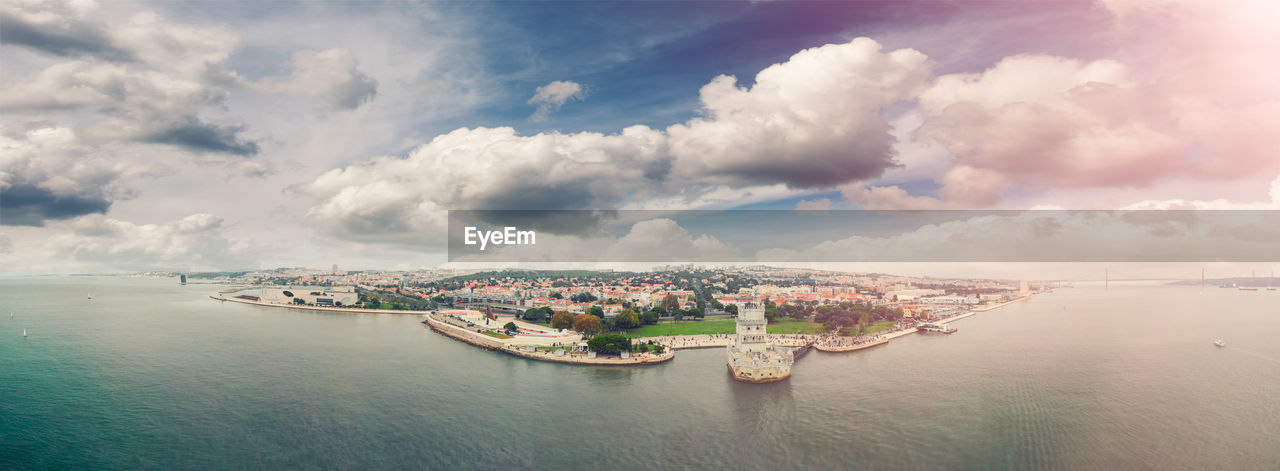 PANORAMIC SHOT OF CITYSCAPE AGAINST CLOUDY SKY