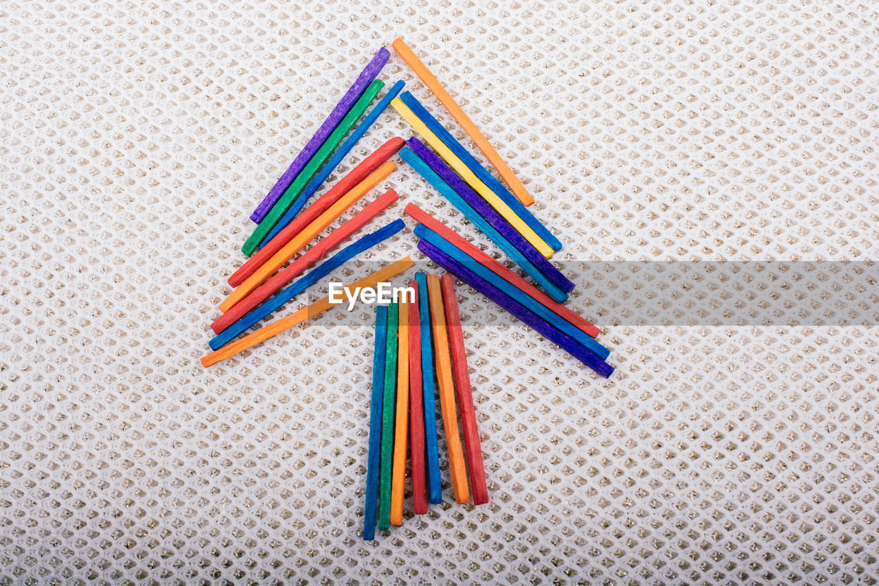 HIGH ANGLE VIEW OF MULTI COLORED PENCILS ON WHITE TABLE