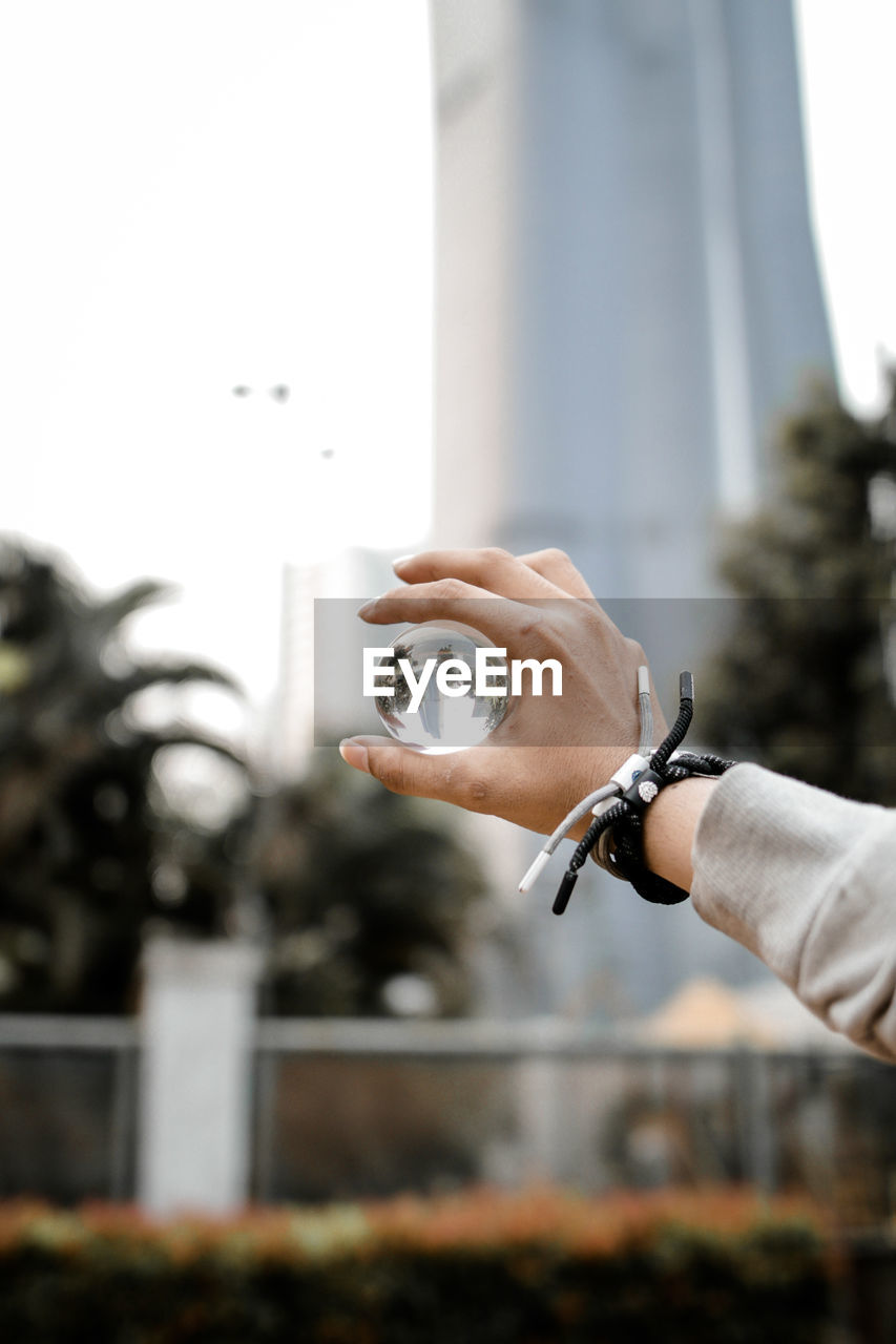 Cropped hand of person holding crystal ball