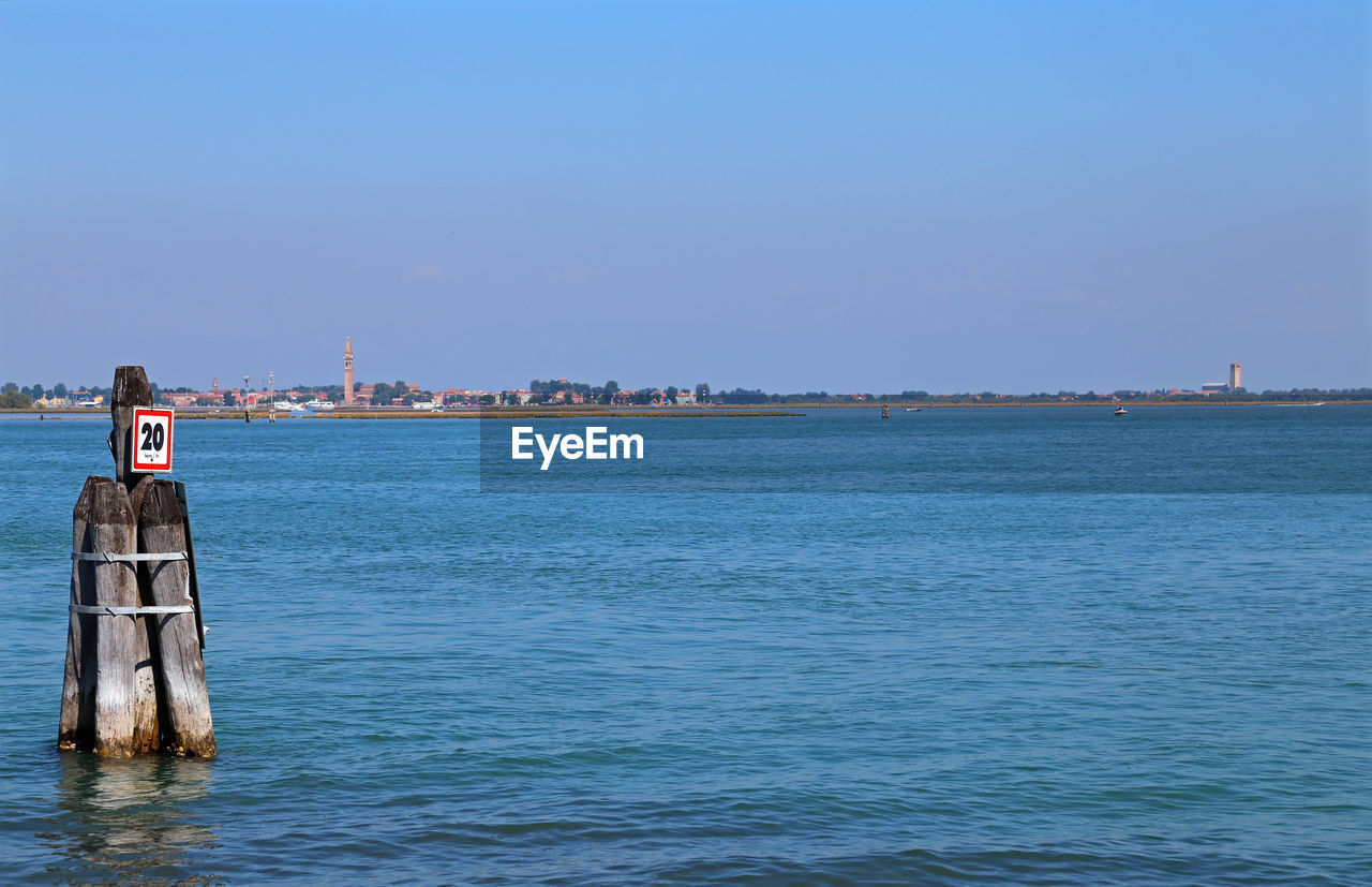 MAN SAILING IN SEA AGAINST CLEAR SKY