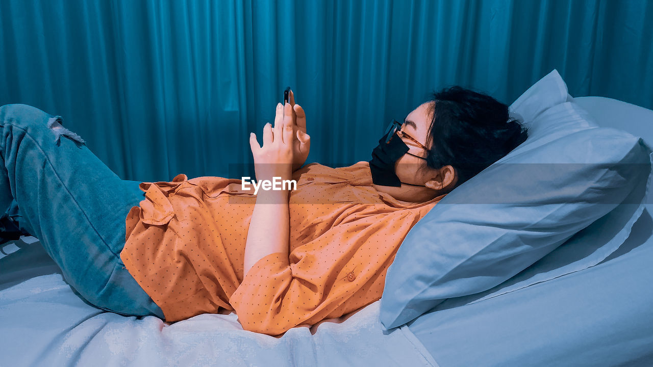 Midsection of woman resting on bed