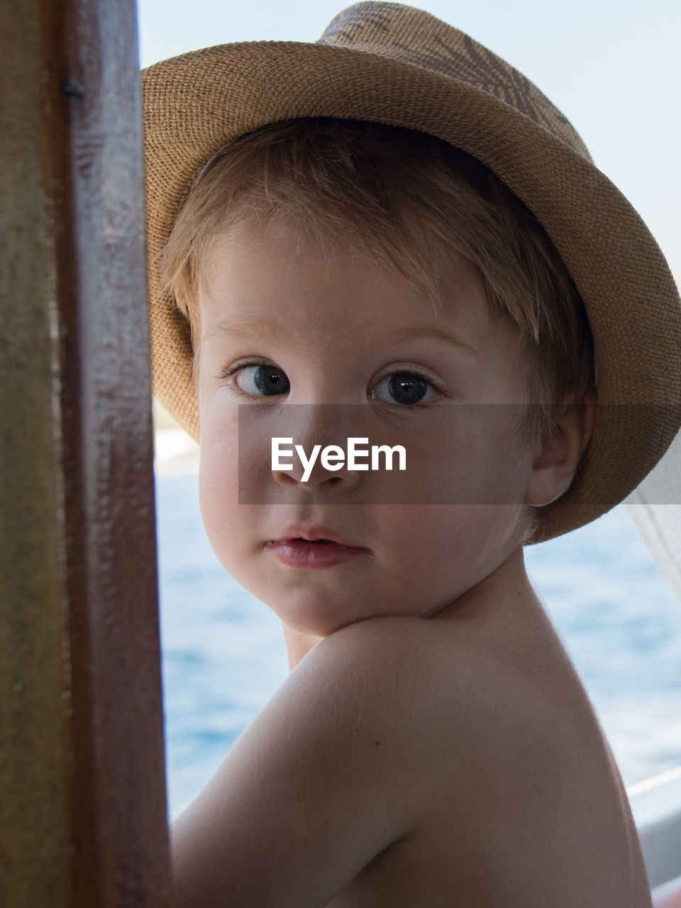 Close-up portrait of shirtless boy wearing hat