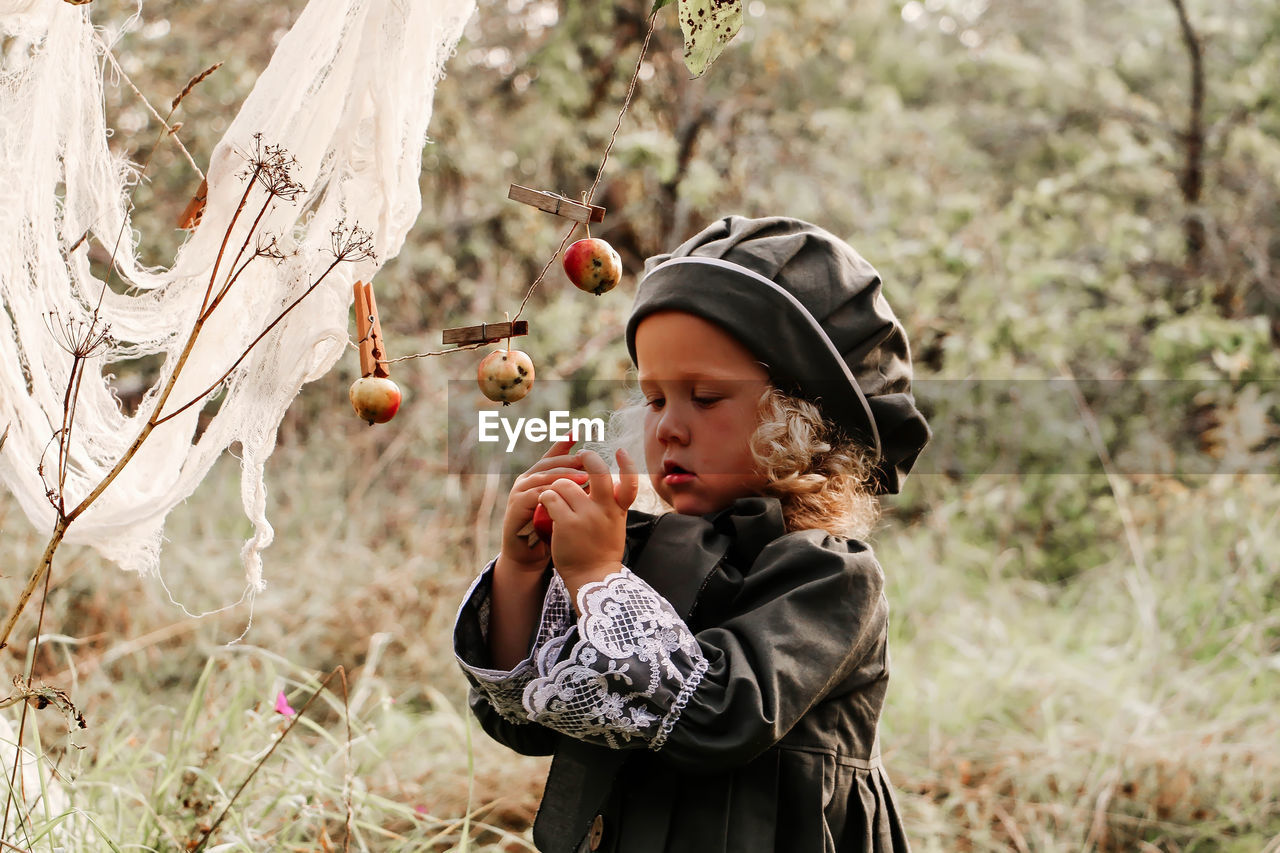 Full length of boy holding apple on land