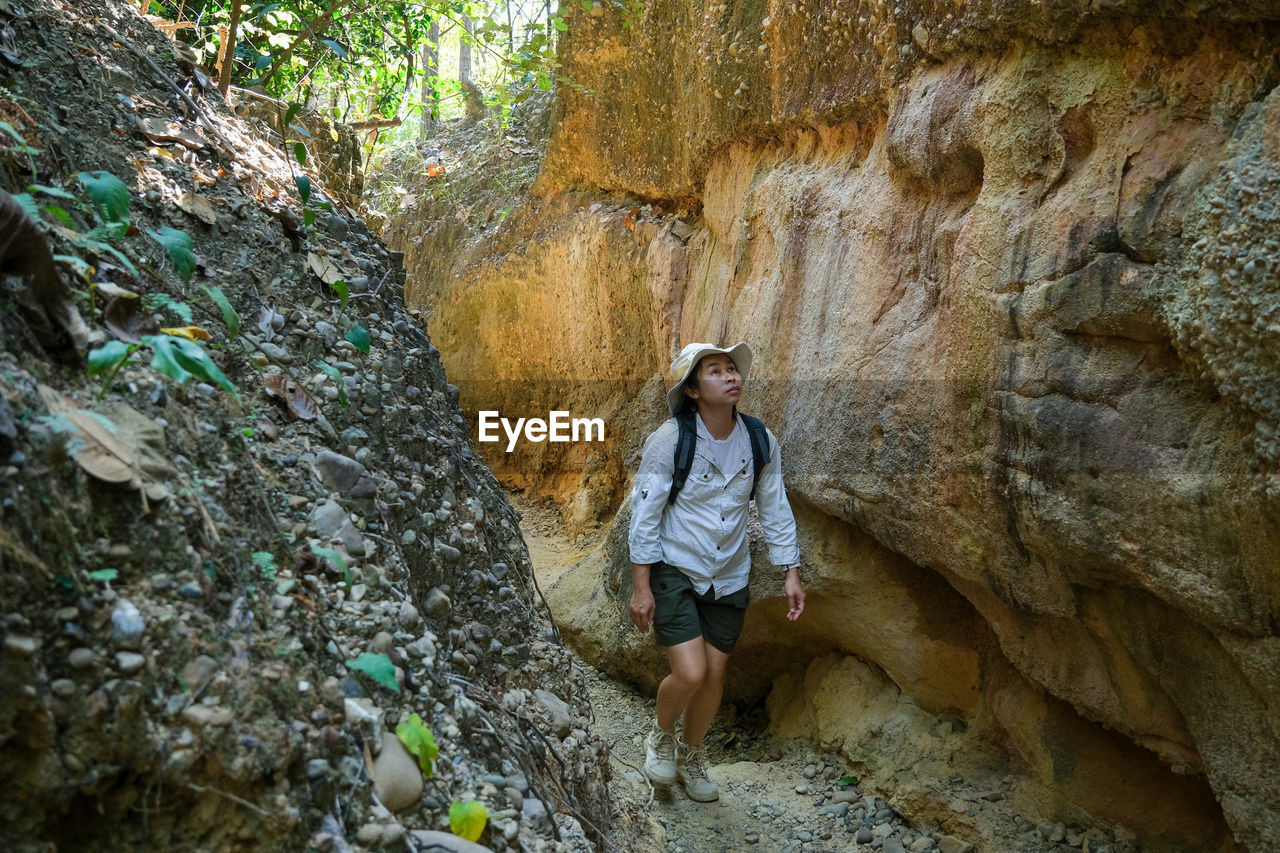 rear view of man standing on rock formations