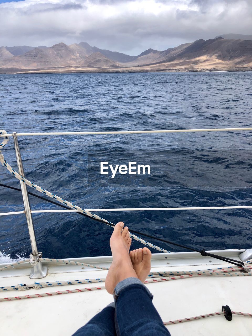 Low section of man relaxing on sailboat