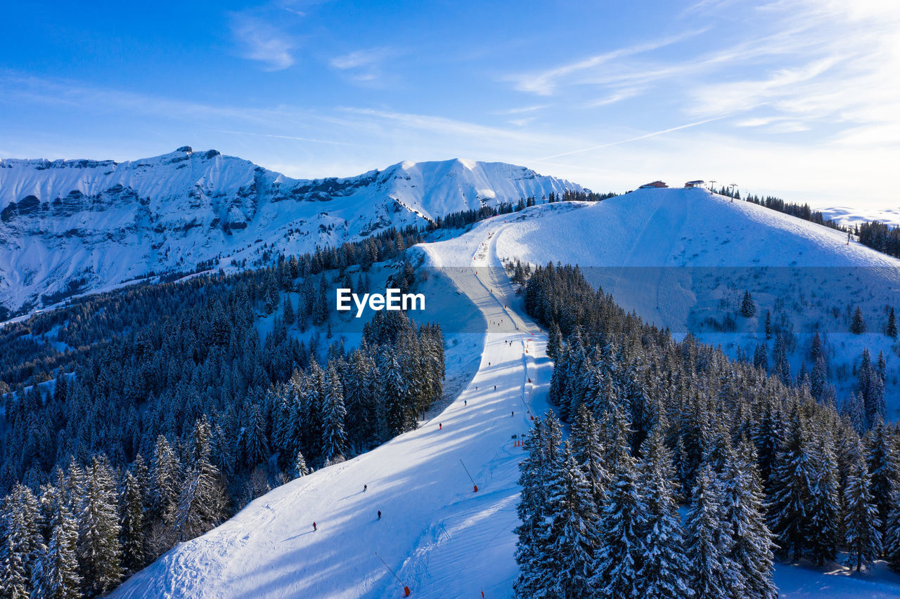 Scenic view of snow covered ski resort against sky