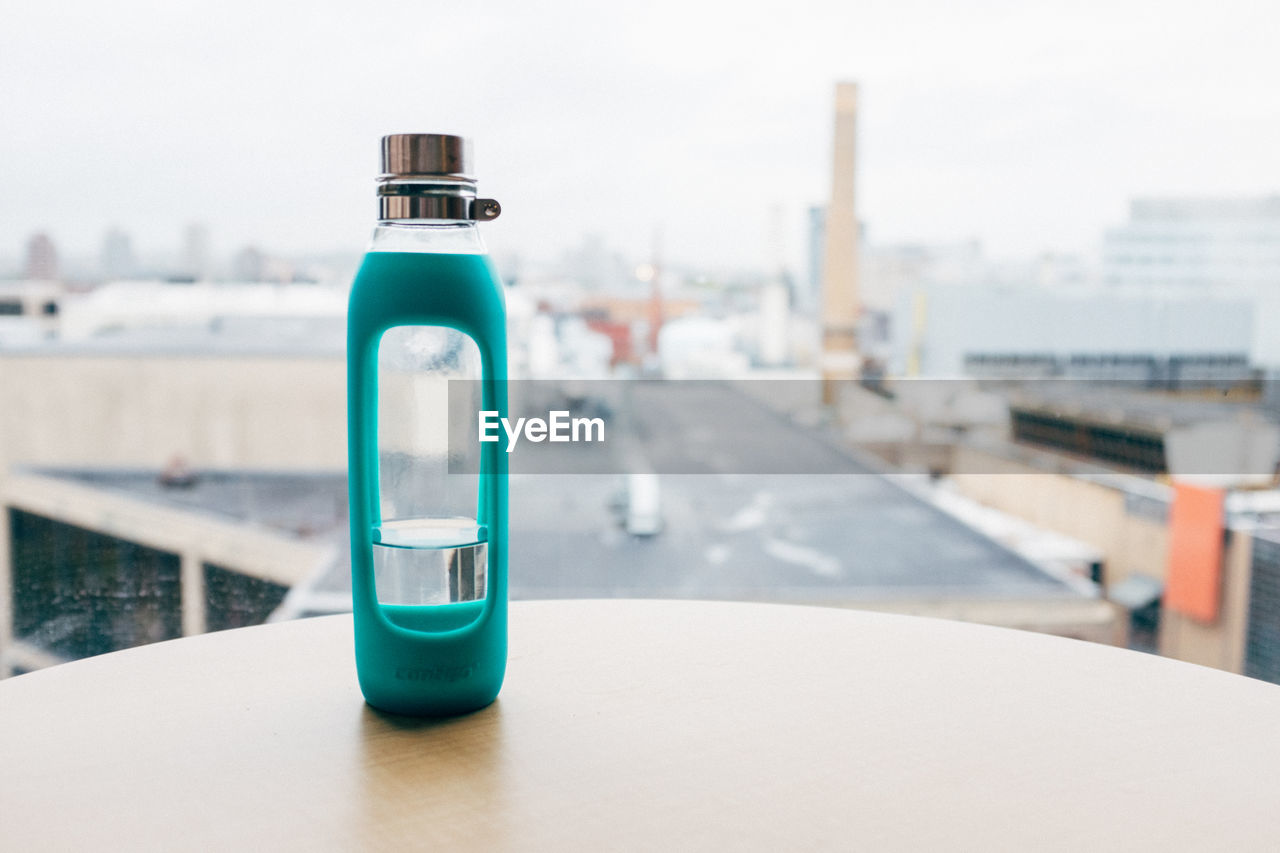 CLOSE-UP OF WATER BOTTLE IN GLASS