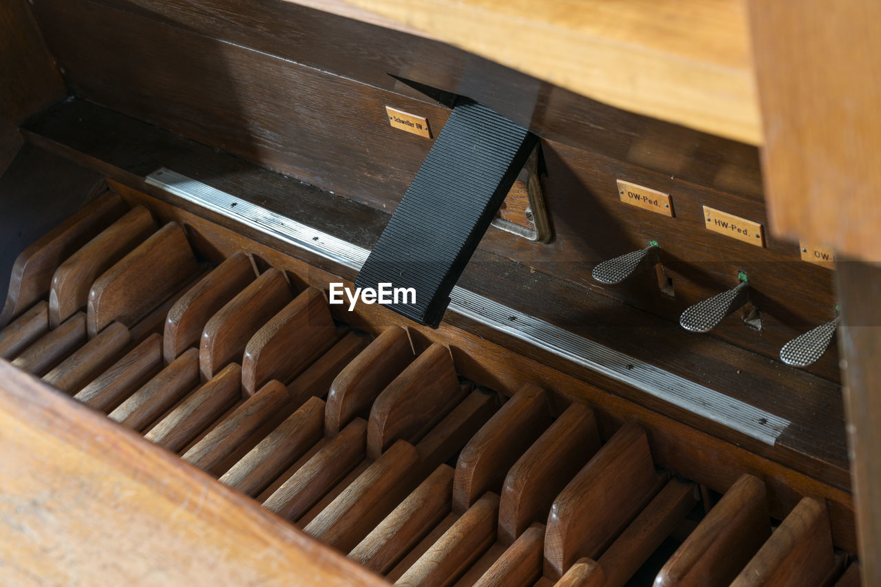 HIGH ANGLE VIEW OF PIANO AND TABLE ON WOOD