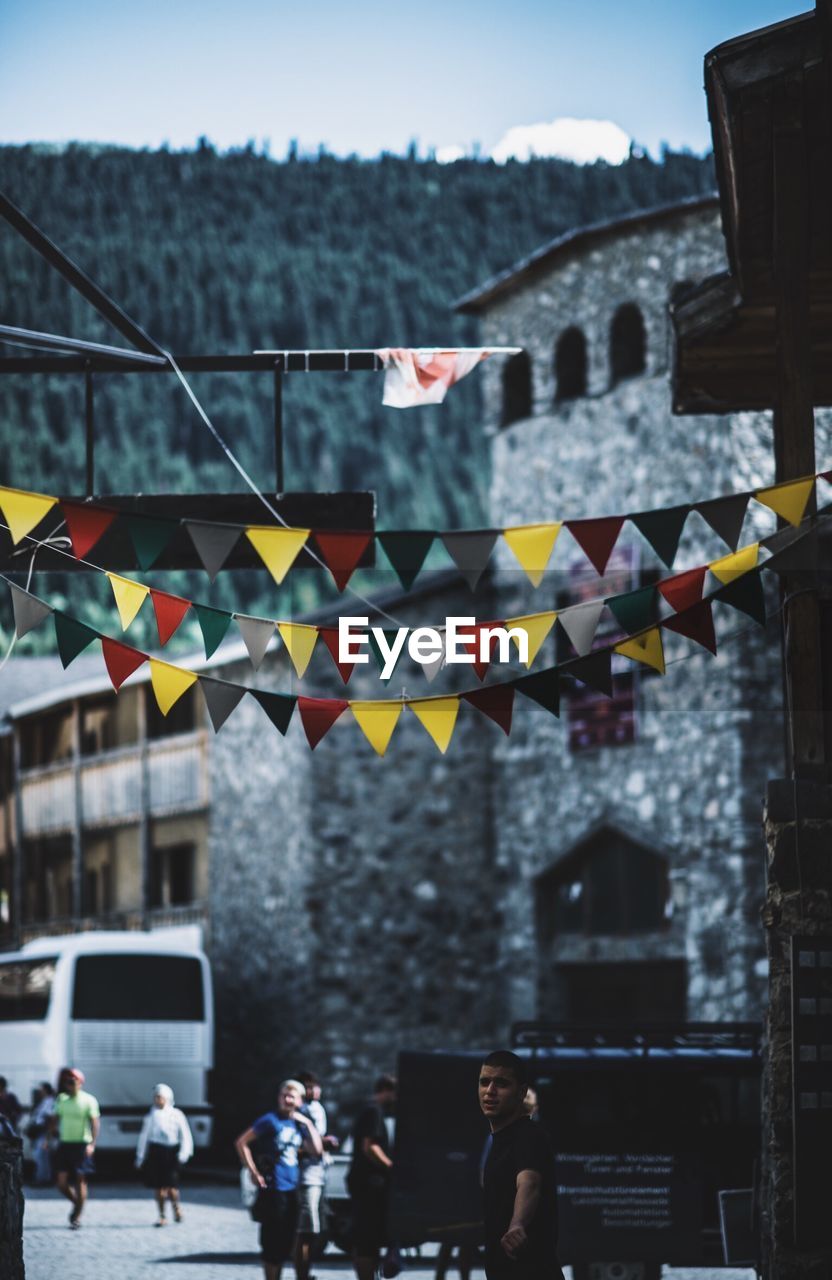 Colorful bunting hanging against buildings in city