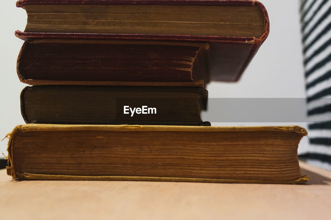 CLOSE-UP OF BOOKS ON WOODEN TABLE