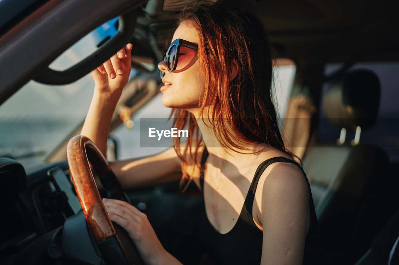 Midsection of woman sitting in car