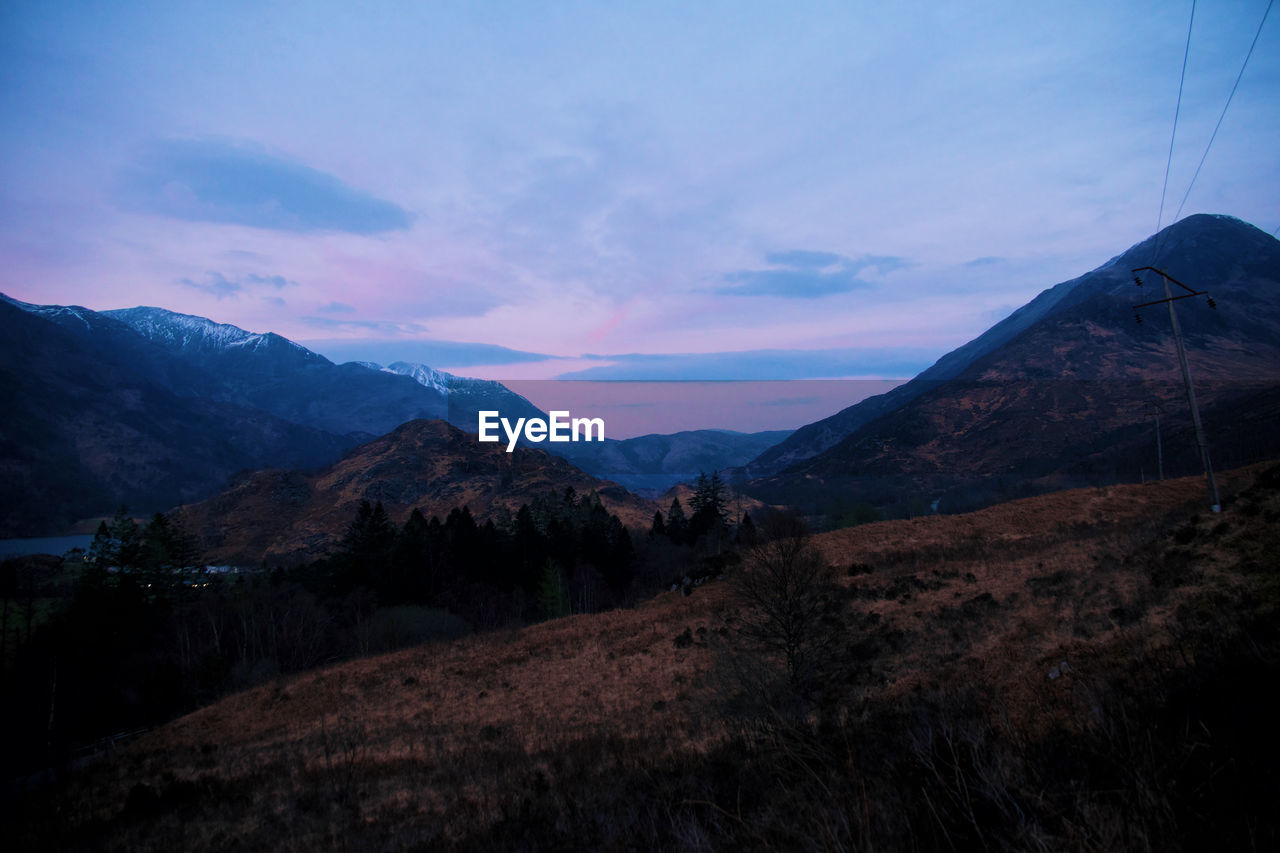 mountain, sky, environment, landscape, scenics - nature, beauty in nature, mountain range, cloud, nature, land, wilderness, no people, tranquility, travel destinations, plant, dawn, tranquil scene, travel, sunset, non-urban scene, tree, outdoors, valley, ridge, blue, night, mountain peak, tourism, forest, idyllic, twilight
