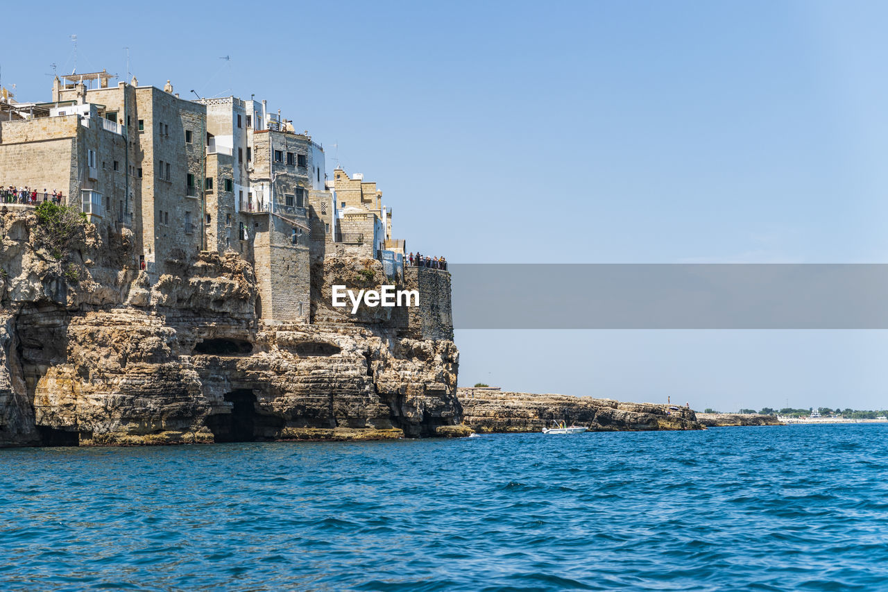 BUILDINGS BY SEA AGAINST SKY