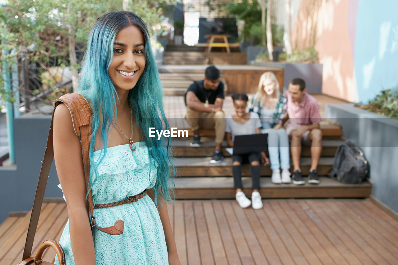 Portrait of young woman with friends in background