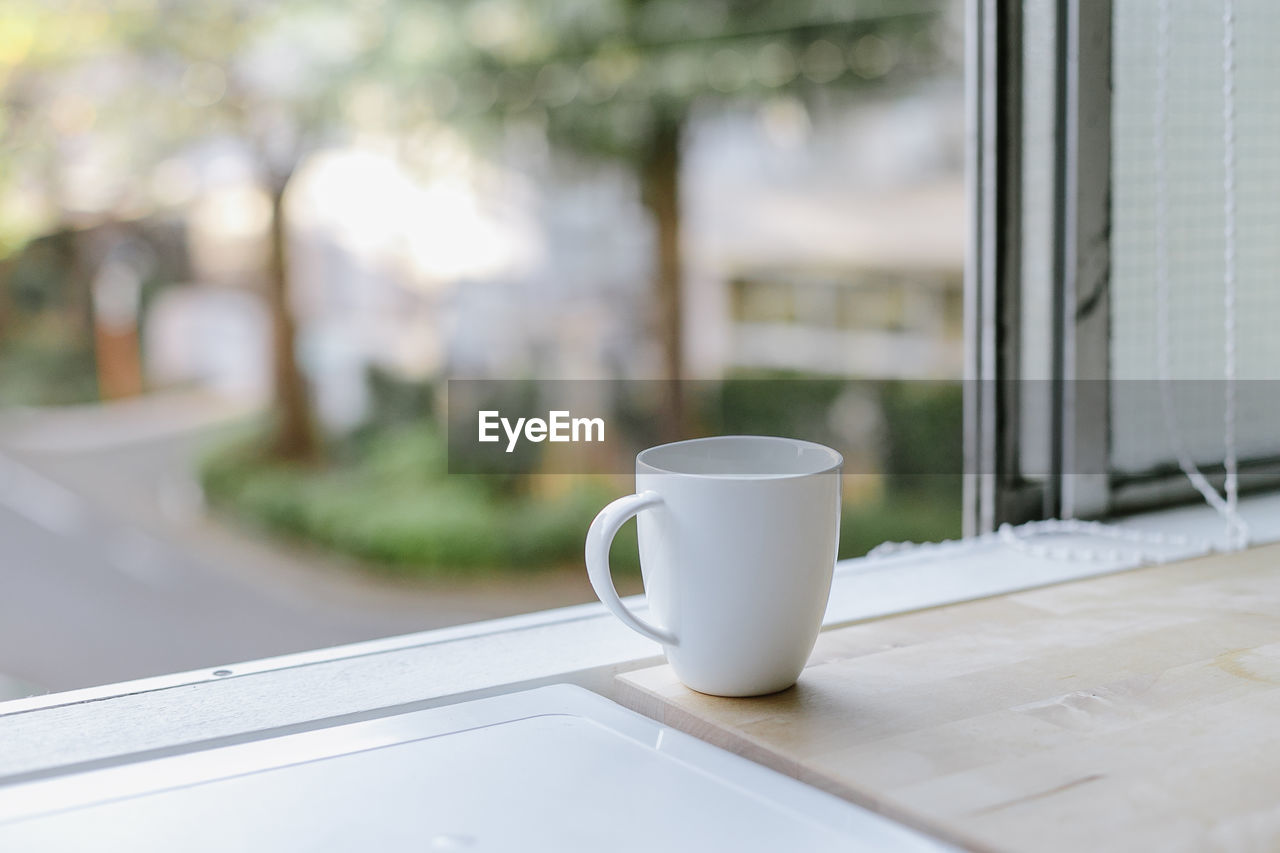 Close-up of coffee cup by window