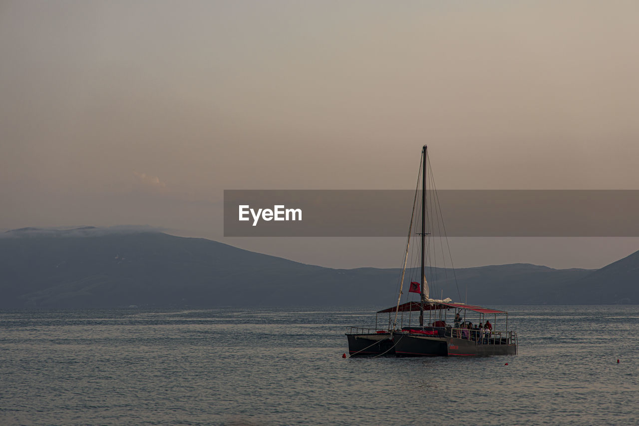 SAILBOAT ON SEA AGAINST SKY DURING SUNSET