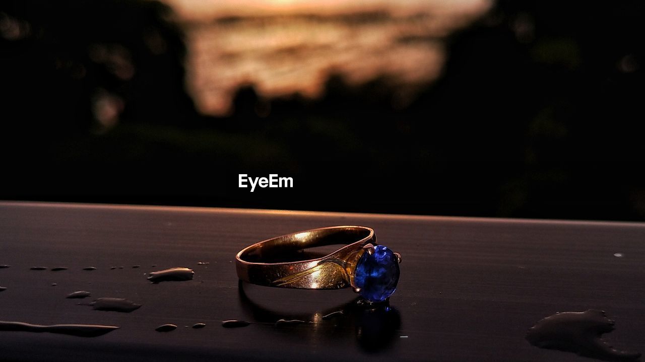 Close-up of engagement ring and sunset 