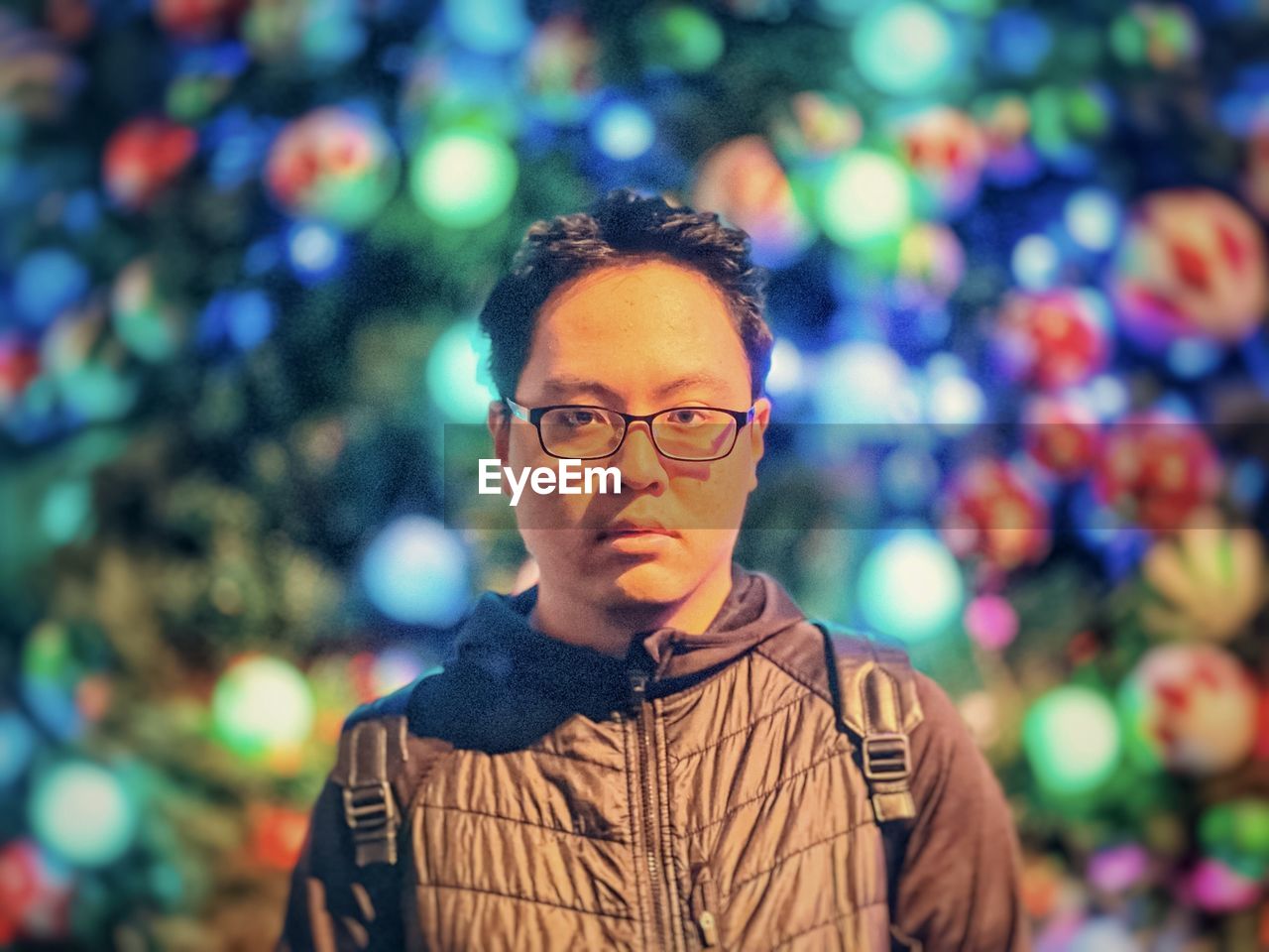 eyeglasses, one person, portrait, glasses, adult, men, christmas tree, person, front view, headshot, focus on foreground, looking, casual clothing, looking at camera, lifestyles, clothing, night, emotion, human face, young adult, celebration, nature, outdoors, multi colored, standing