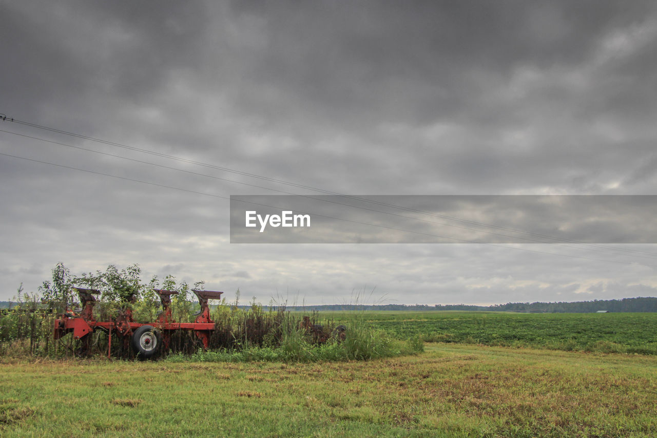 Scenic view of grassy field against cloudy sky