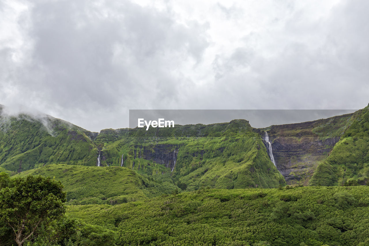 Scenic view of mountains against cloudy sky