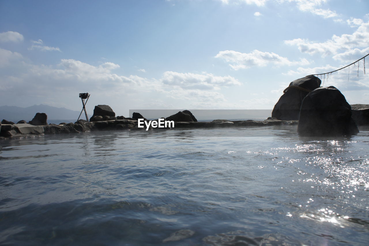 SEA BY ROCKS AGAINST SKY