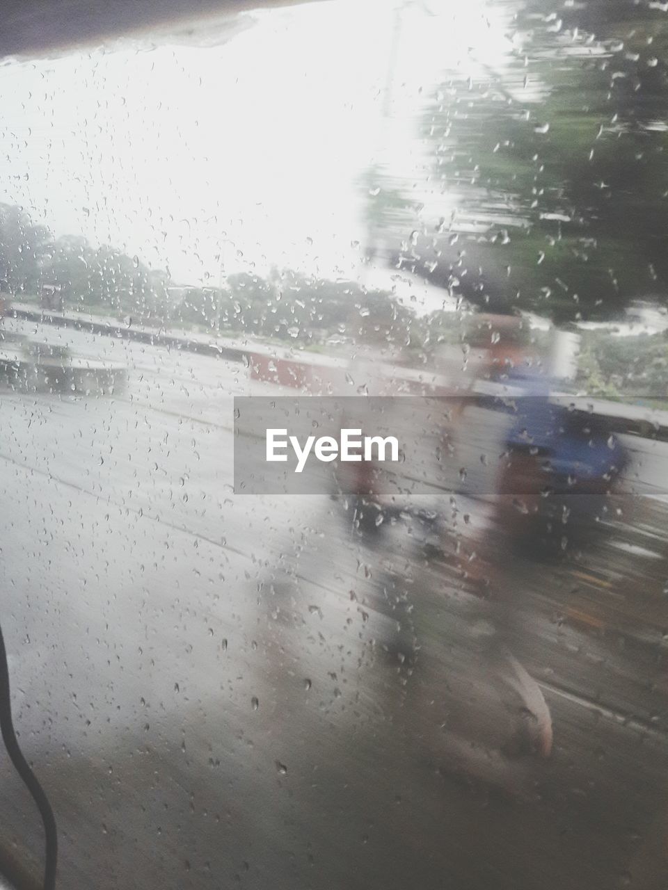 WATER DROPS ON GLASS WINDOW AGAINST SKY DURING RAINY SEASON