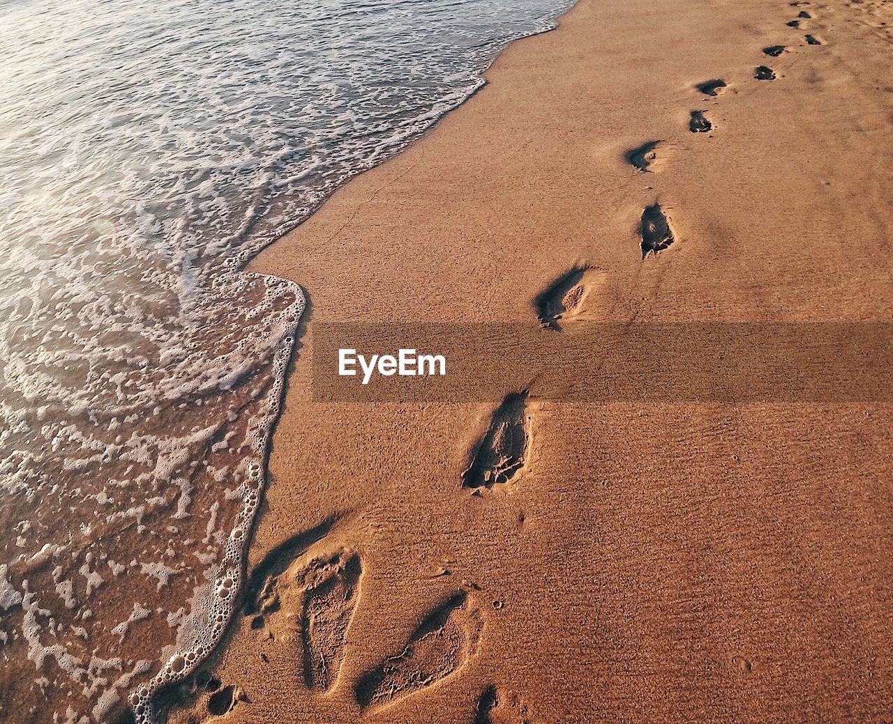 High angle view of footprints on sand at beach