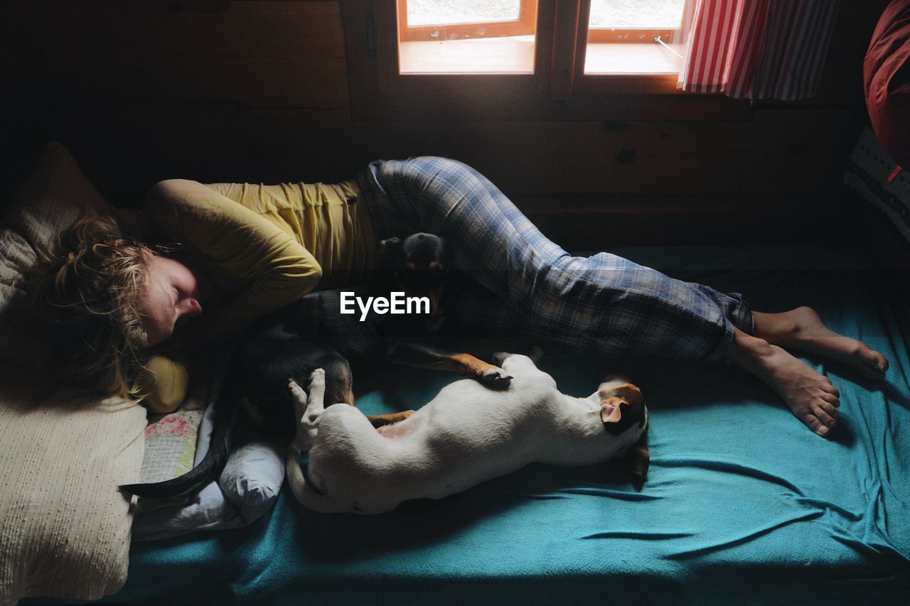 Woman with dogs relaxing on bed